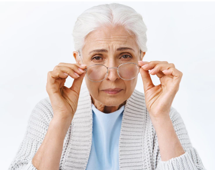 노안으로 인해 안경으로 초점을 잡고 있는 백발의 여성