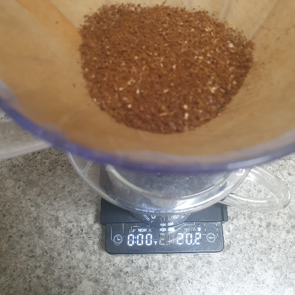 저울 위에 서버에 장착된 드리퍼가 올려져있다. 저울은 20.2g을 가르키고 있다. 드리퍼 안에는 분쇄된 원두가 들어있다.