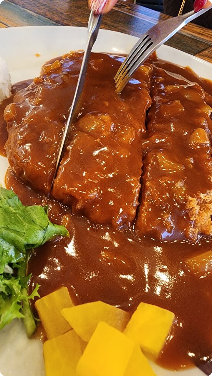 돈까스를 칼로 자르는 음식 한 접시