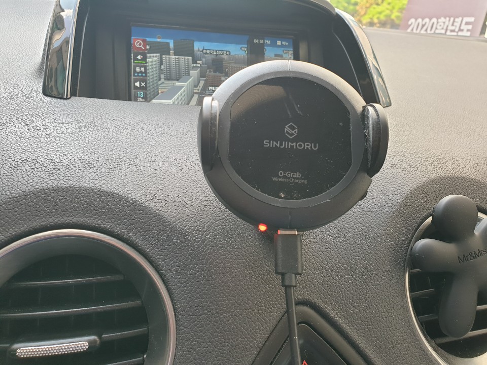 차량 대시보드에 부착된 신지모루 오그랩 거치대, 빨간 LED 불이 켜져 있는 모습