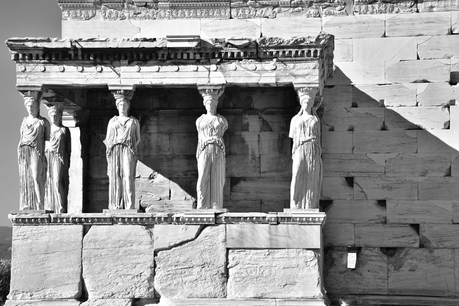 Black and white photo of the Caryatids, ancient Greek sculptures, on the Erechtheion temple, Athens.