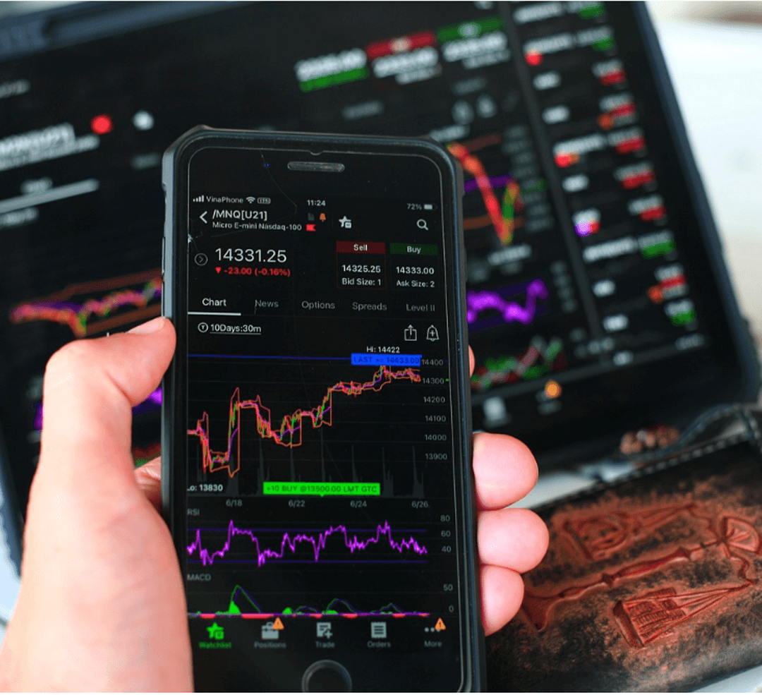 스마트폰으로 주식 상황을 확인해 보는 사람 손과 스마트폰 주식의 그래프 보임