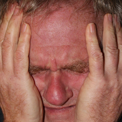 통증으로 얼굴을 감싸고 있는 남성