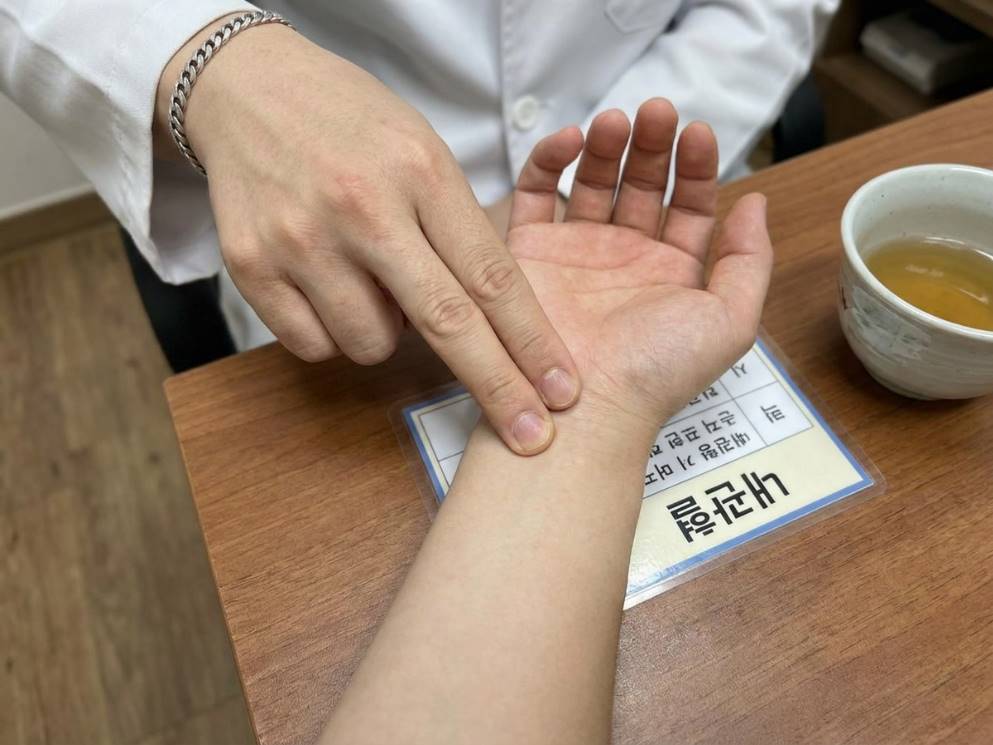 손목 안쪽 내관혈 위치를 손가락으로 지압하는 모습