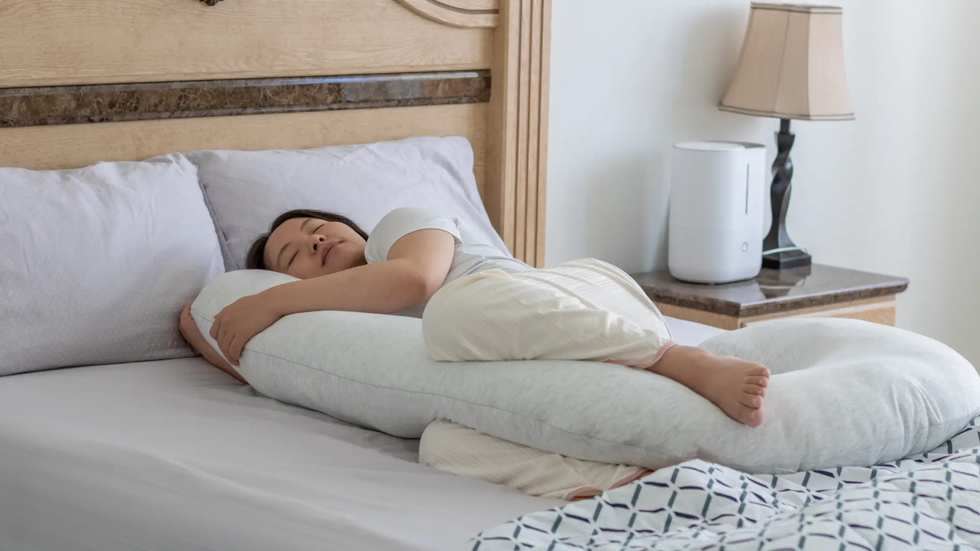 배게를 안고 옆으로 자는 여성