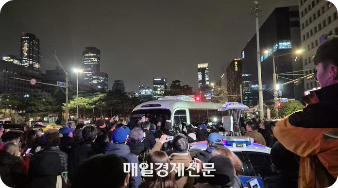 비상계엄 상황이던 작년 12월 4일 자정쯤 서울 여의도 국회 정문 앞 상황. 시민들이 군부대에서 파견된 버스 앞을 가로막고 연신 &ldquo;계엄 철폐&rdquo; 구호를 외치고 있다. [사진=매일경제, 이상현 기자]
