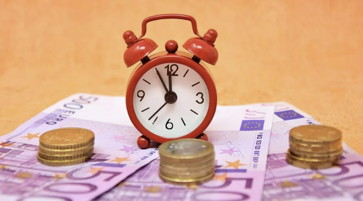 지폐위에 동전과 자명종시계