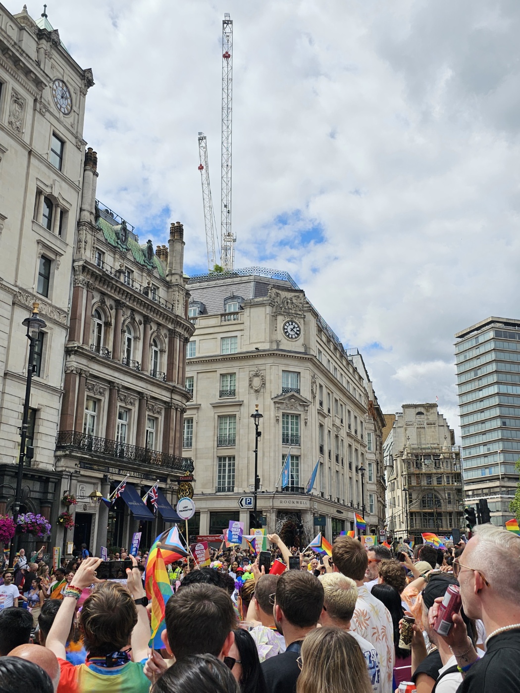 푸른 하늘 아래&amp;#44; 퀴퍼 참여 단체의 트럭이 지나간다. 많은 관중이 맞아주고 있다. 무지개 깃발이 많이 보이고&amp;#44; 스마트폰으로 촬영하는 사람들도 있다.