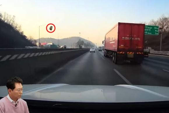 고속도로 주행 중 난데없이 날아온 돌덩이에 차량이 파손되는 사고를 겪은 운전자 사연이 전해졌다. 사진은 운전자 차량을 향해 돌덩이가 날아오고 있는 모습. [사진=유튜브 '한문철 TV']