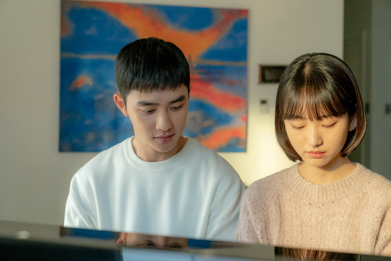 피아노 앞에 앉아있는 남자와 여자