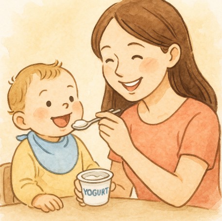 아기에게 유산균이 든 요거트를 먹이며 미소 짓는 엄마의 모습