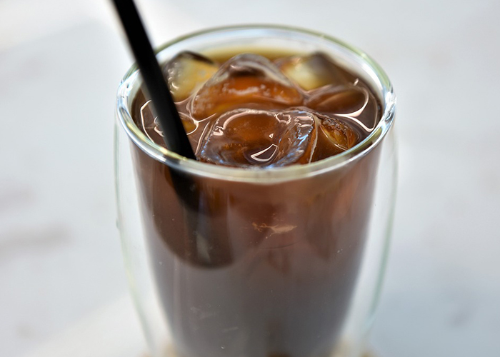 투명한 유리컵에 아이스 커피가 담겨져있다.