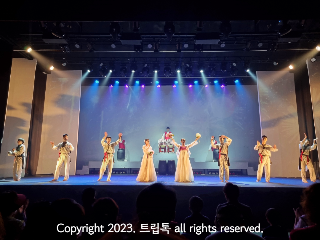 무대위에서 하얀 옷을 입은 사람들이 공연하고 있다