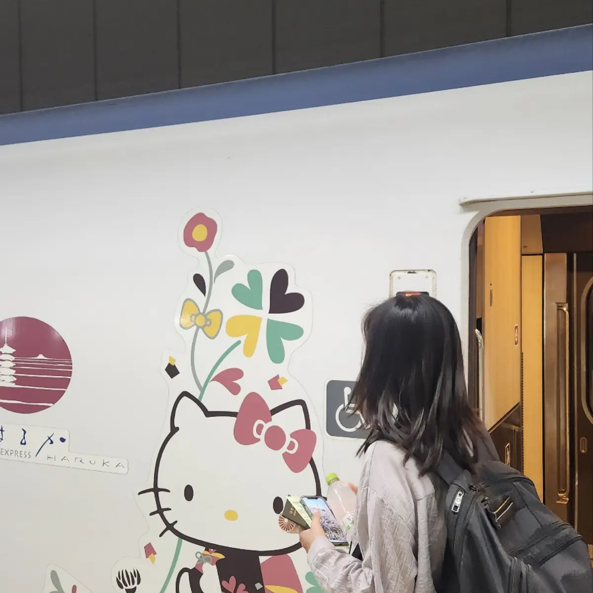 하루카-열차-헬로키티-옆에-서있는-여자