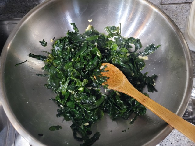 미역을 마늘과 함께 참기름에 볶는 모습