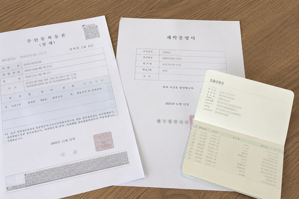 초등학교 입학 축하금 신청 준비 서류인 주민등록등본과 통장 사본을 정리하는 모습