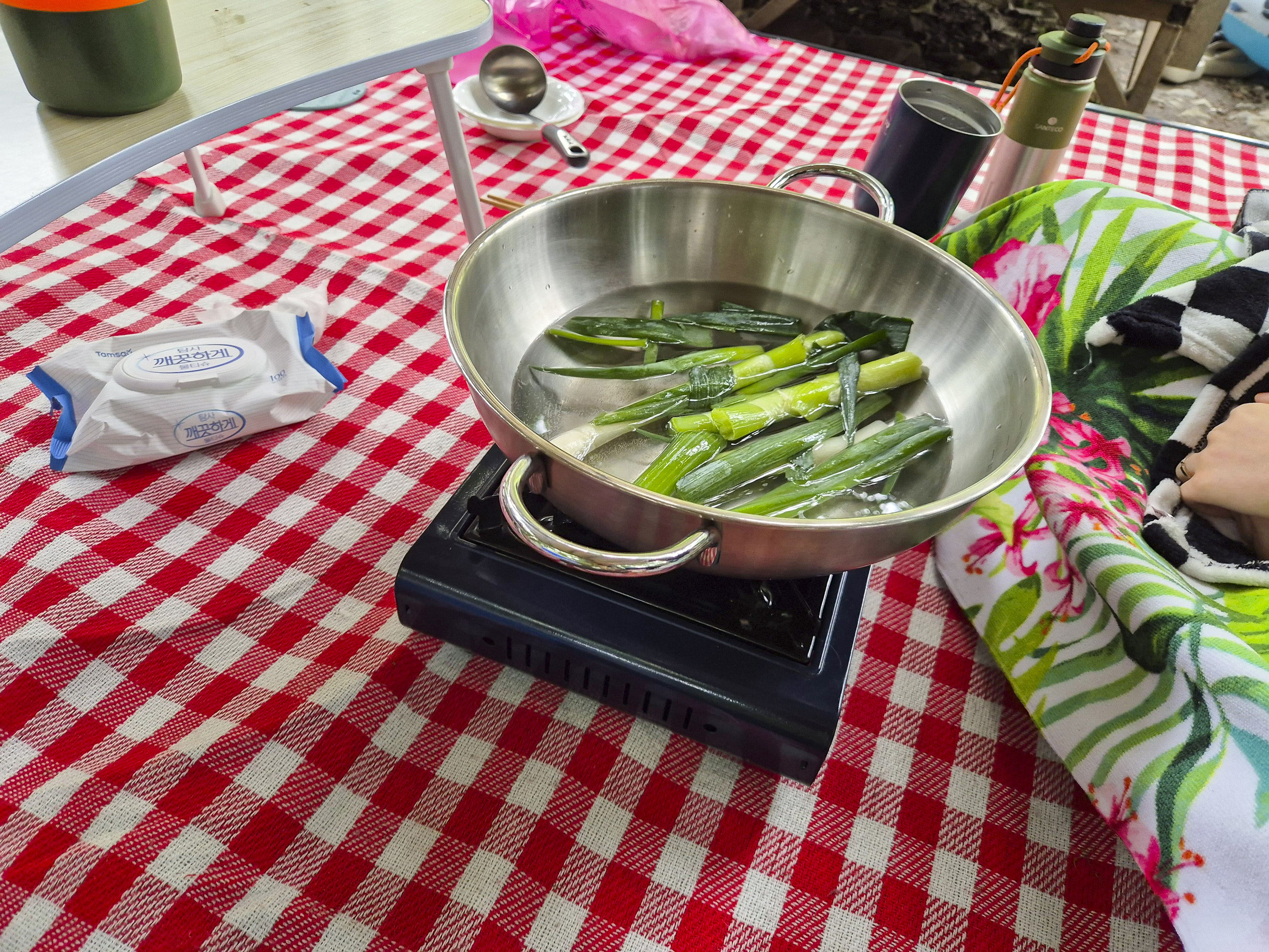 평상에 앉아 라면 끓여 먹기 위해 파 육수 내는 모습.