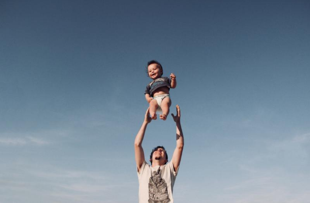 아빠가 아들을 높이 들고 있다.