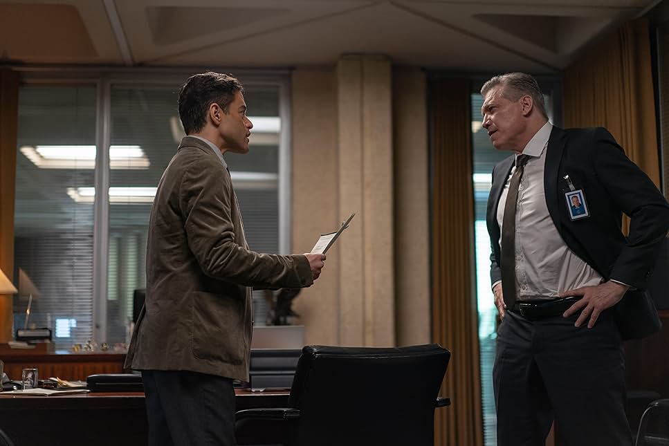 영화 The Amateur 속 한 장면 : 첩보 사무실에서 말렉과 요원의 긴장 대치