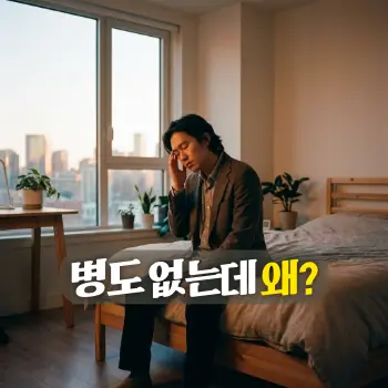 병도 없는데 왜?
어스름한 저녁, 창밖으로 도시의 불빛이 은은하게 들어오는 방 안에서 침대 가장자리에 걸터앉아 피로감에 지친 표정으로 관자놀이를 가볍게 짚고 있는 30대 한국인 직장인의 모습.