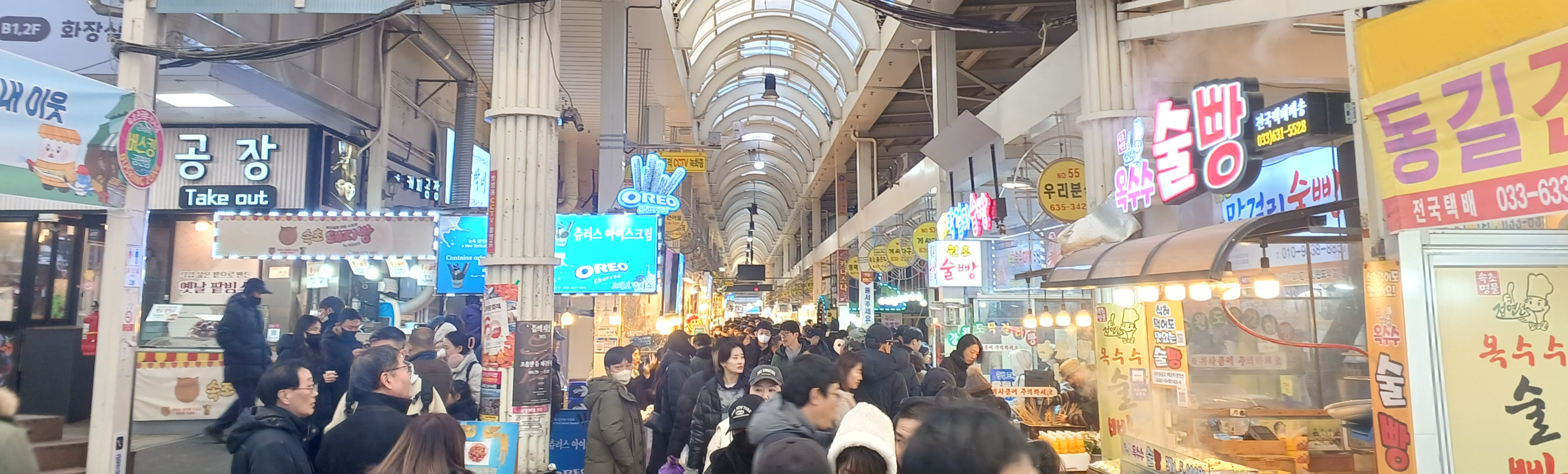 속초 관광수산시장 내부의 상점들과 활기찬 방문객들의 모습