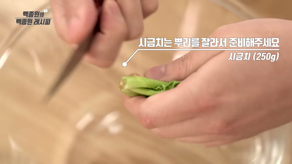 칼로 시금치 뿌리를 손질하는 장면