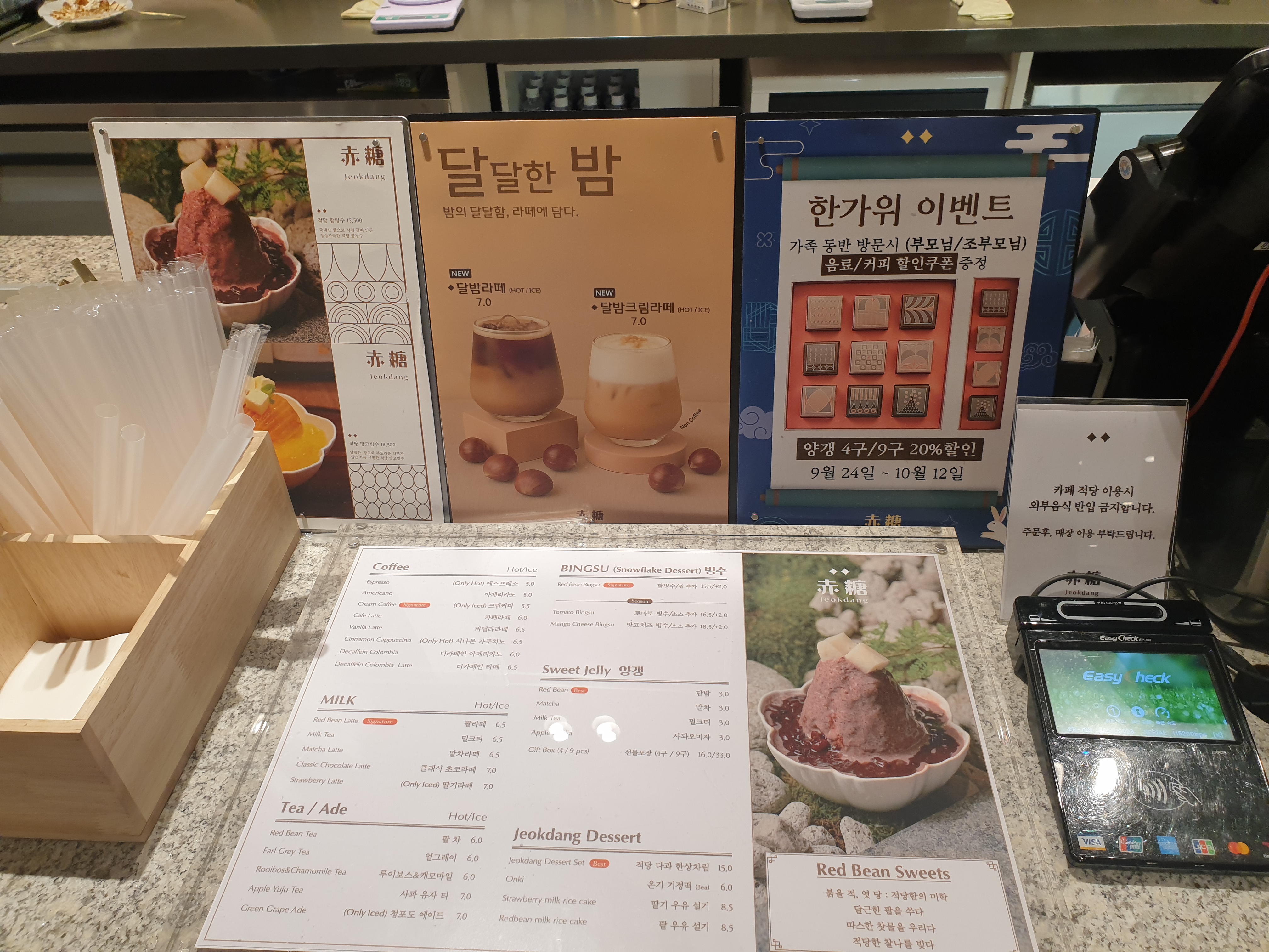 메인 메뉴판과 시즌 메뉴 POP 그리고 카드 결제기가 놓인 카운터