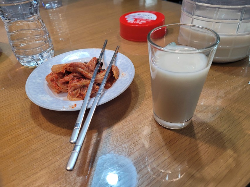 직접 만든 찹쌀막걸리를 잔에 따라 마시는 모습