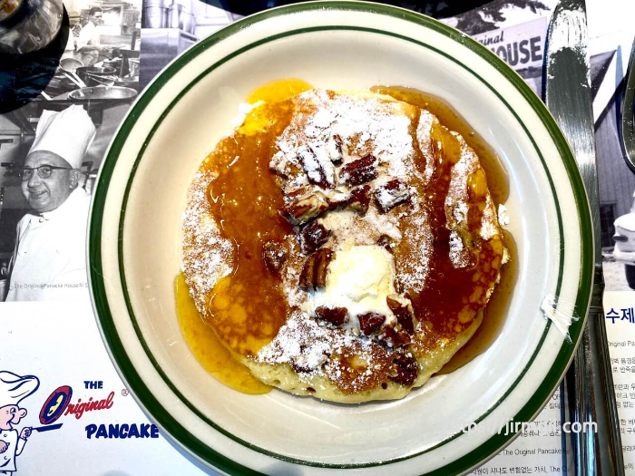 오렌지향_시럽과_메이플_시럽을_절반씩_부어놓은_피칸_팬케이크