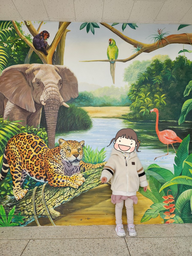 동물 벽화 앞의 아이