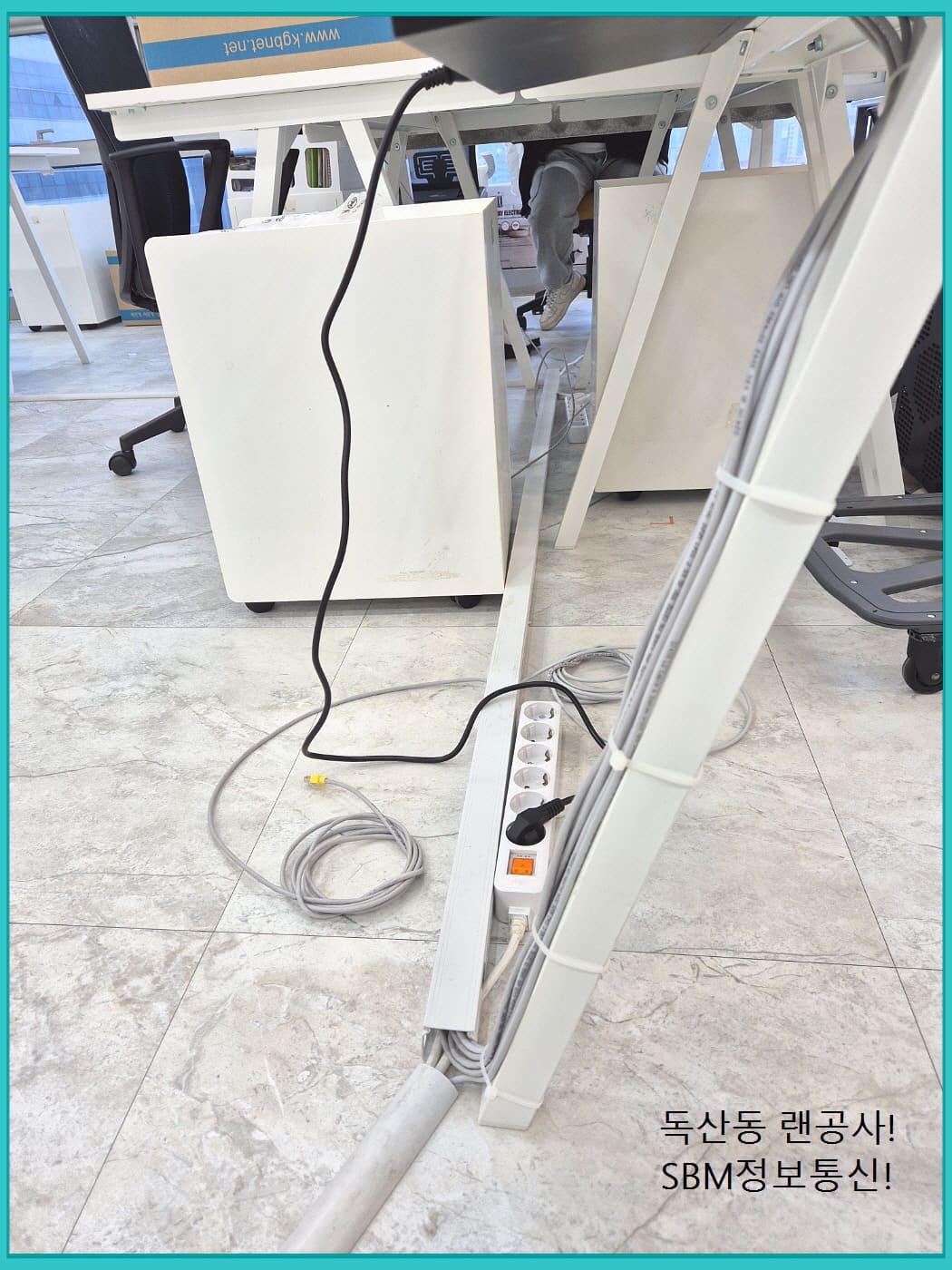 책상 다리를 타고 내려오는 깔끔한 벨크로 타이 마감과 전원 탭 정리