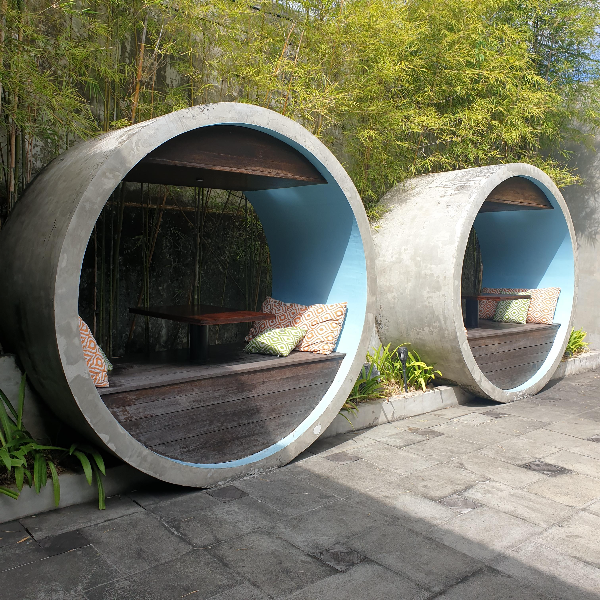 야외 대나무가 있고 원형 파이프 안에 좌석이 있다.