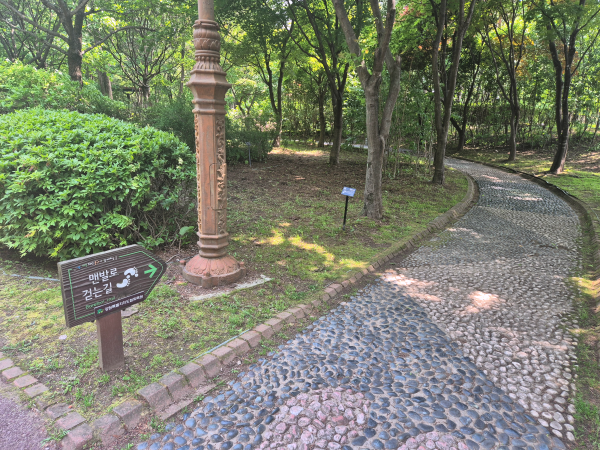 '맨발로 걷는 길' 표지판과 조약돌이 깔린 지압길