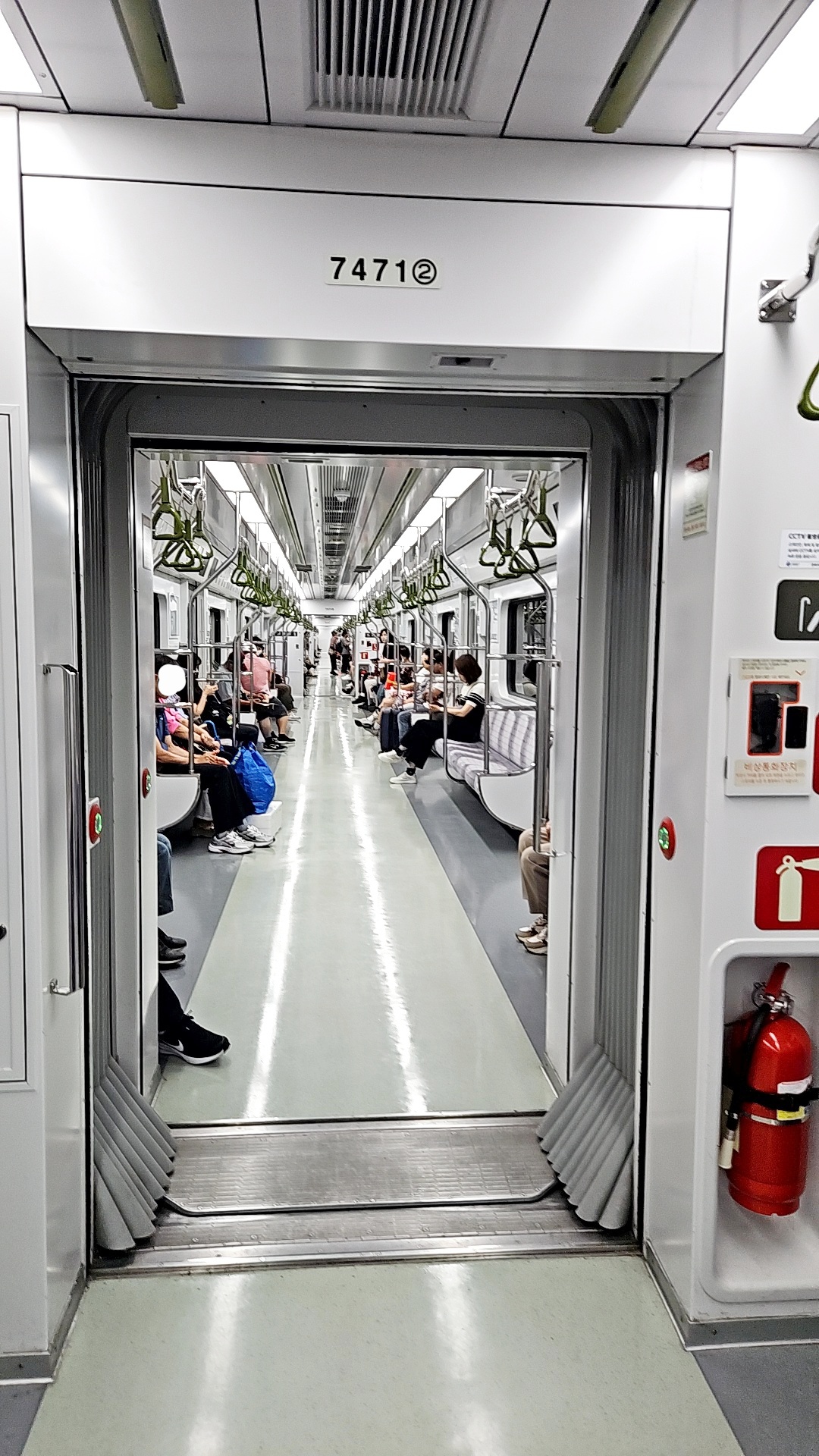 지하철-전동칸에있는-소화기-좌석에-앉아있는-사람들