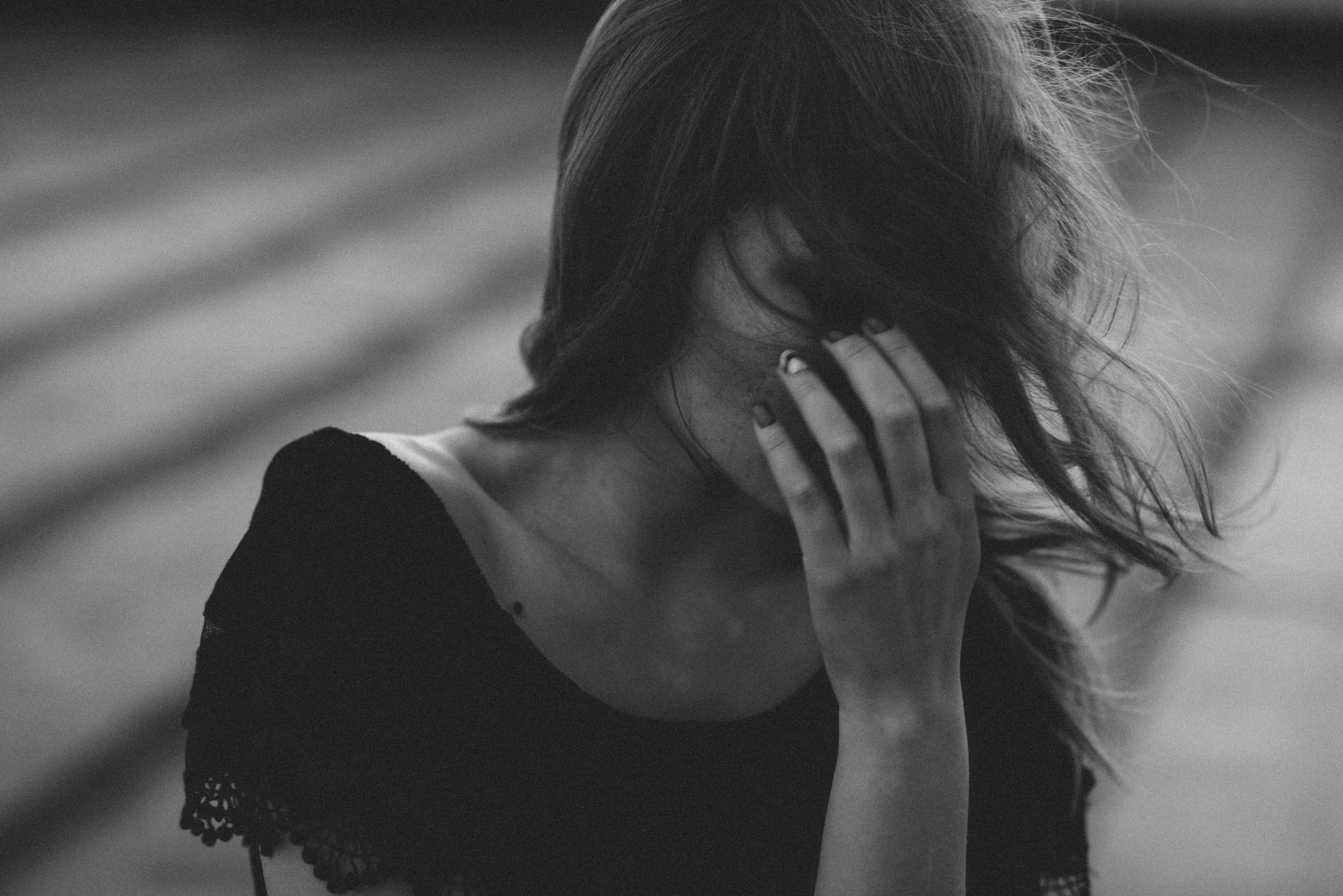 감정적으로 지친 여성이 머리를 감싼 채 고개를 숙이고 있는 장면, 감정 회피와 뇌 피로를 시각적으로 표현한 이미지