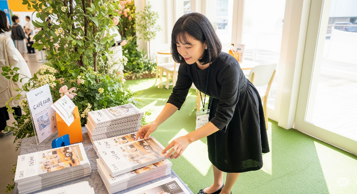 카페 박람회에서 카탈로그를 정리하는 여성