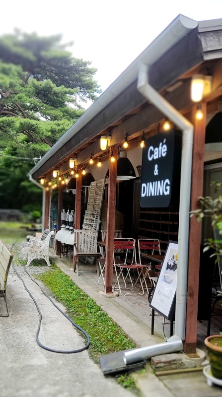 나무로된 건물에 에디슨 조명들과 테이블 의자