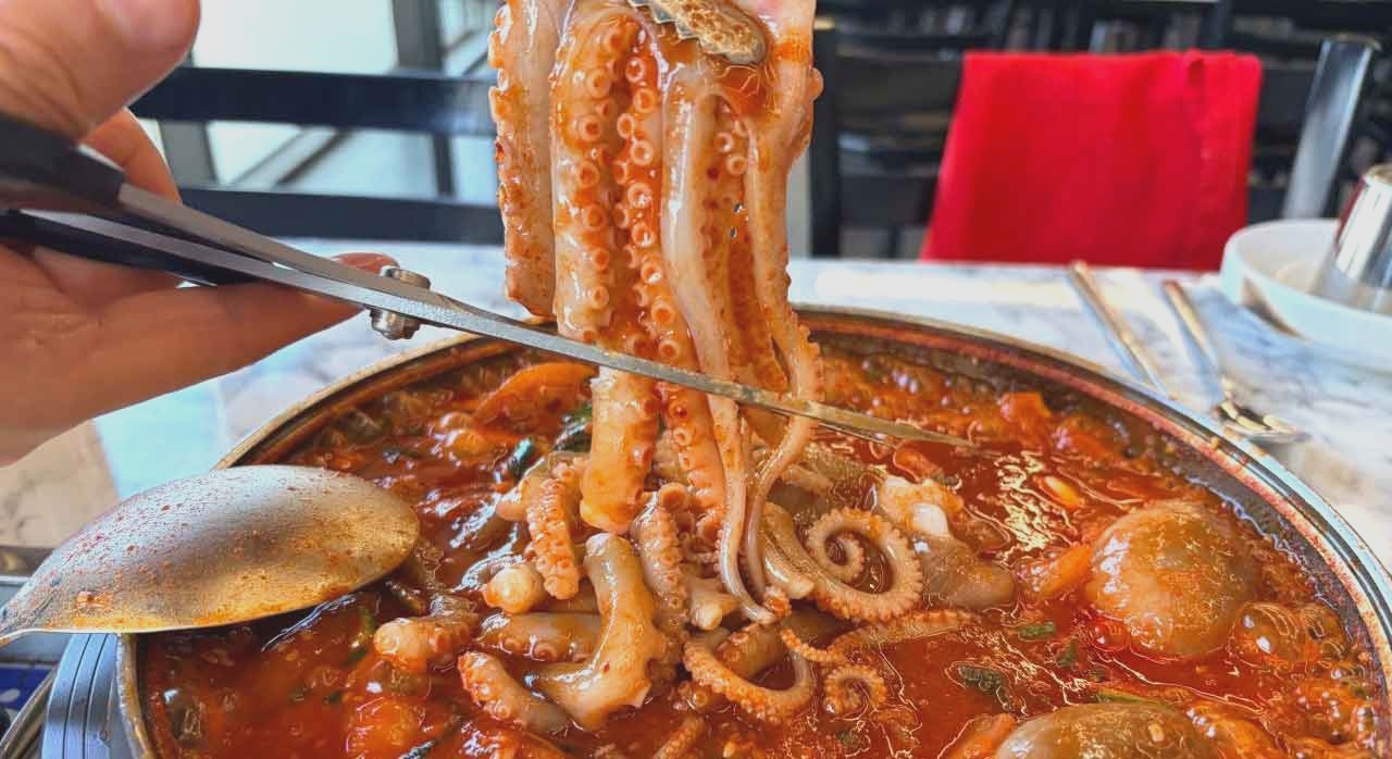 빨갛게 끓는 전골 속 낙지를 자르는 모습. [ⓒ네이버플레이스 빨간거짱구네 송도점]