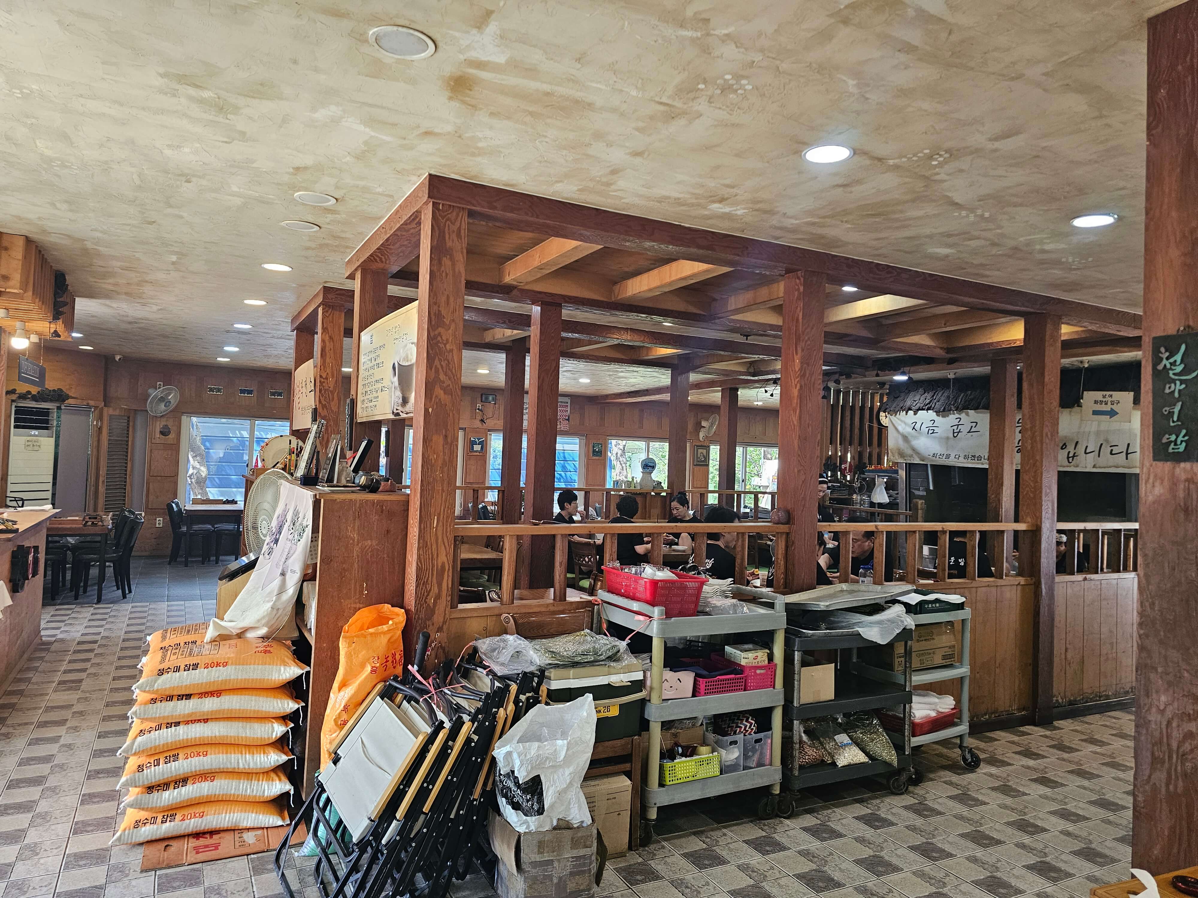 연잎밥집의 내부 사진으로 나무로 짠기둥들과 그뒤에 식사하고 계신분들이 있네요