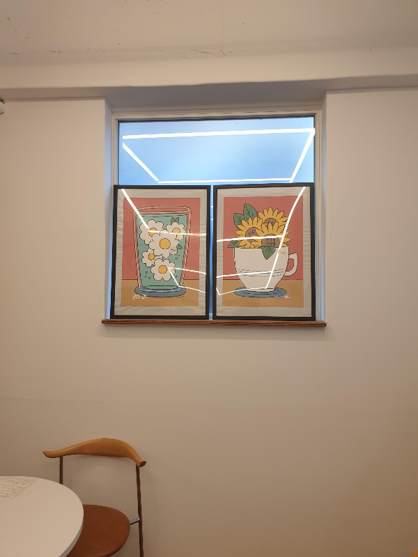 흰 벽에 액자 두 개. 미니멀하게 보인다. 카페 안도 우드 인테리어다.