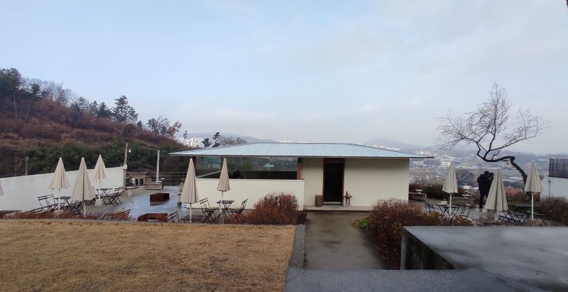 야외 공간 시골집같은 별채하나가 있고 야외 테이블이 자리;함