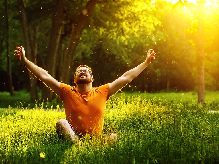 숲에서 햇살에 기지개를 켜는 남자