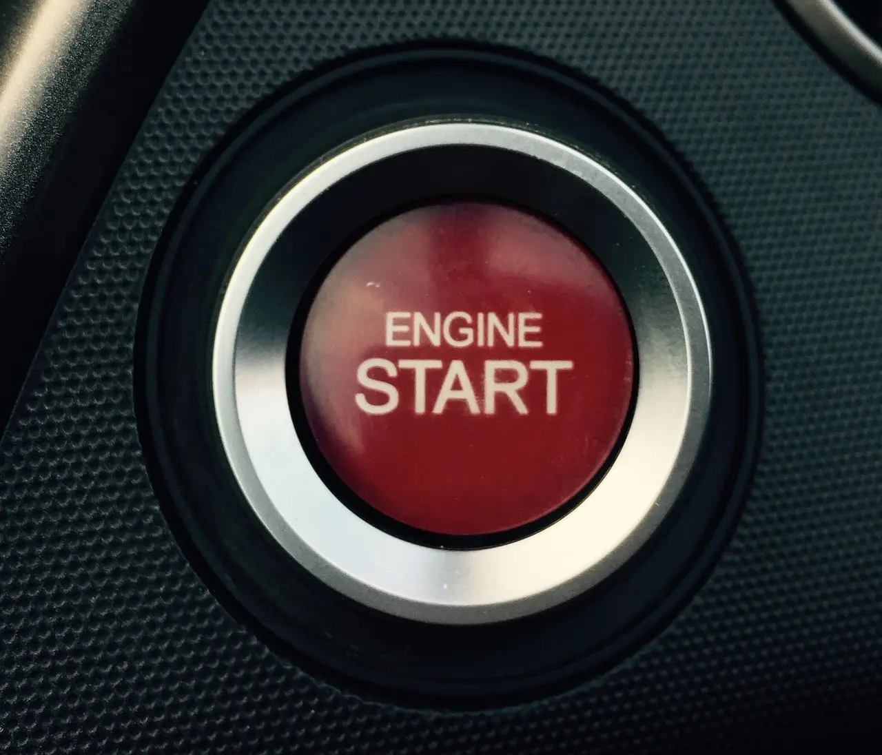 혼유사고- 검은 바탕 가운데 흰색 스텐동그라미 안 빨간 버튼 안 흰글씨 engine start