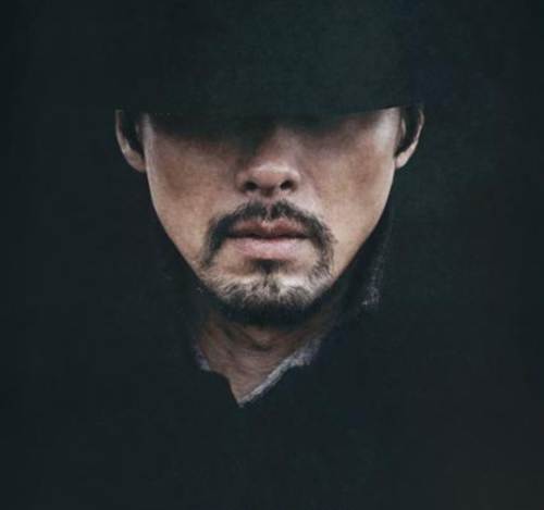 하얼빈의 안중근역을 맞은 주인공이 어둠속에서 중절모를 쓰고 있는 모습