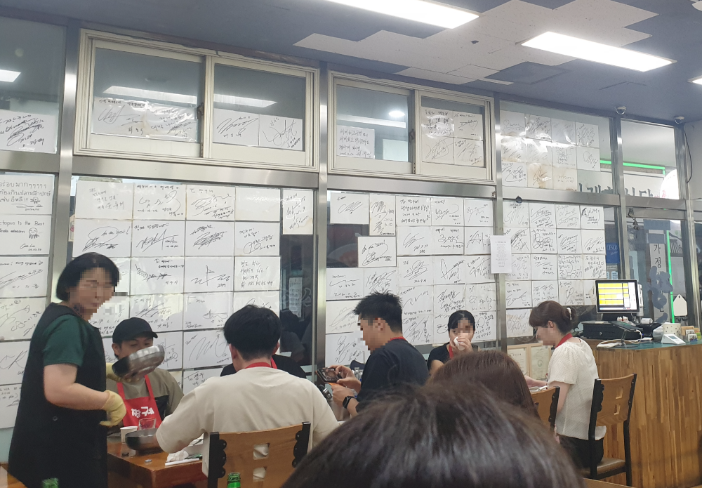 유리면에 가득히 유명인들의 사인이 부착되어 있다.