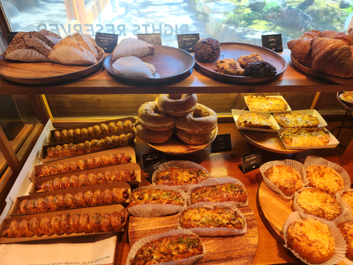 Scones, cookies, bagels, and sausage pastries are on a plate.