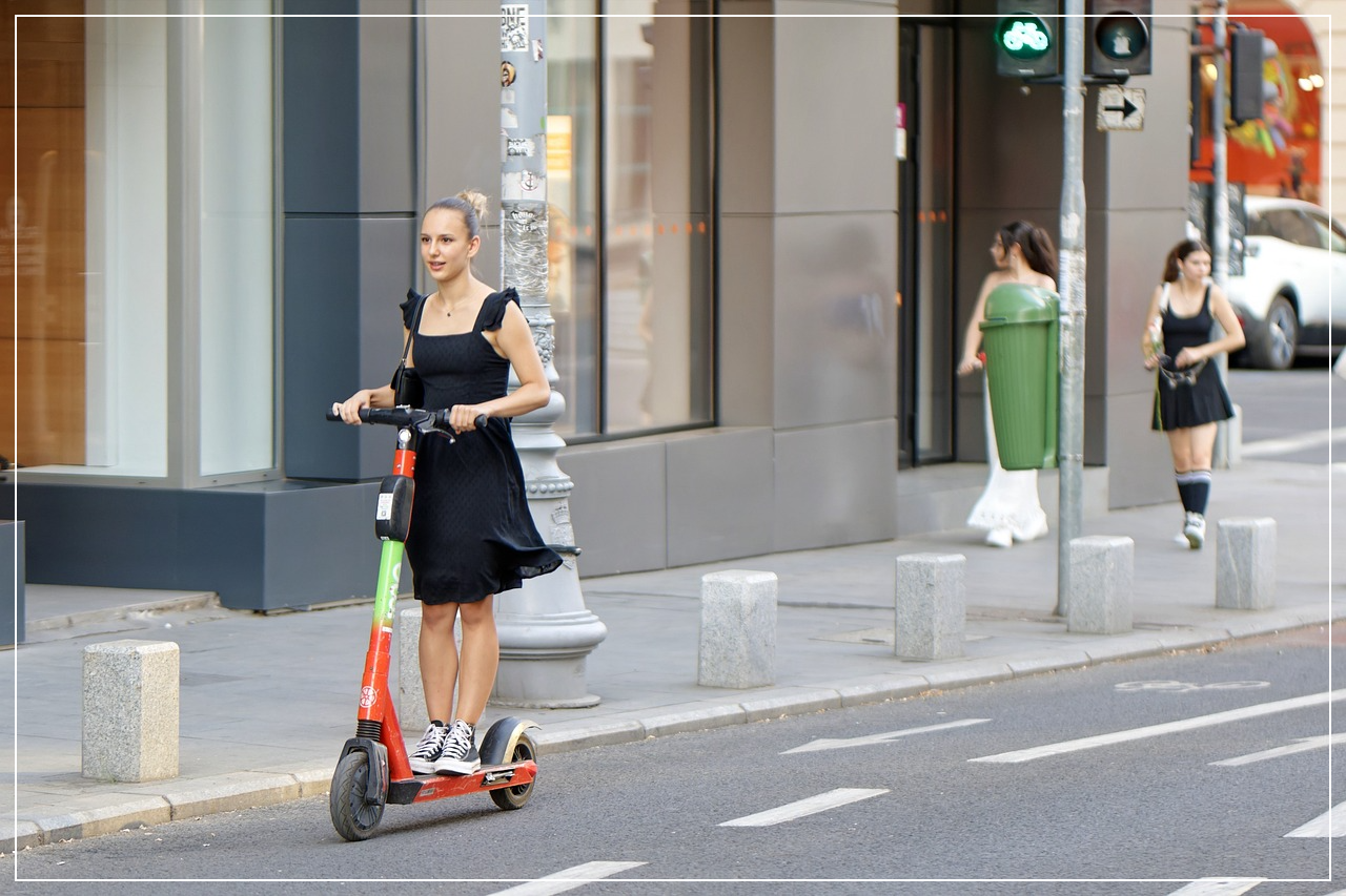전동킥보드를 타고 도로를 주행중인 여성