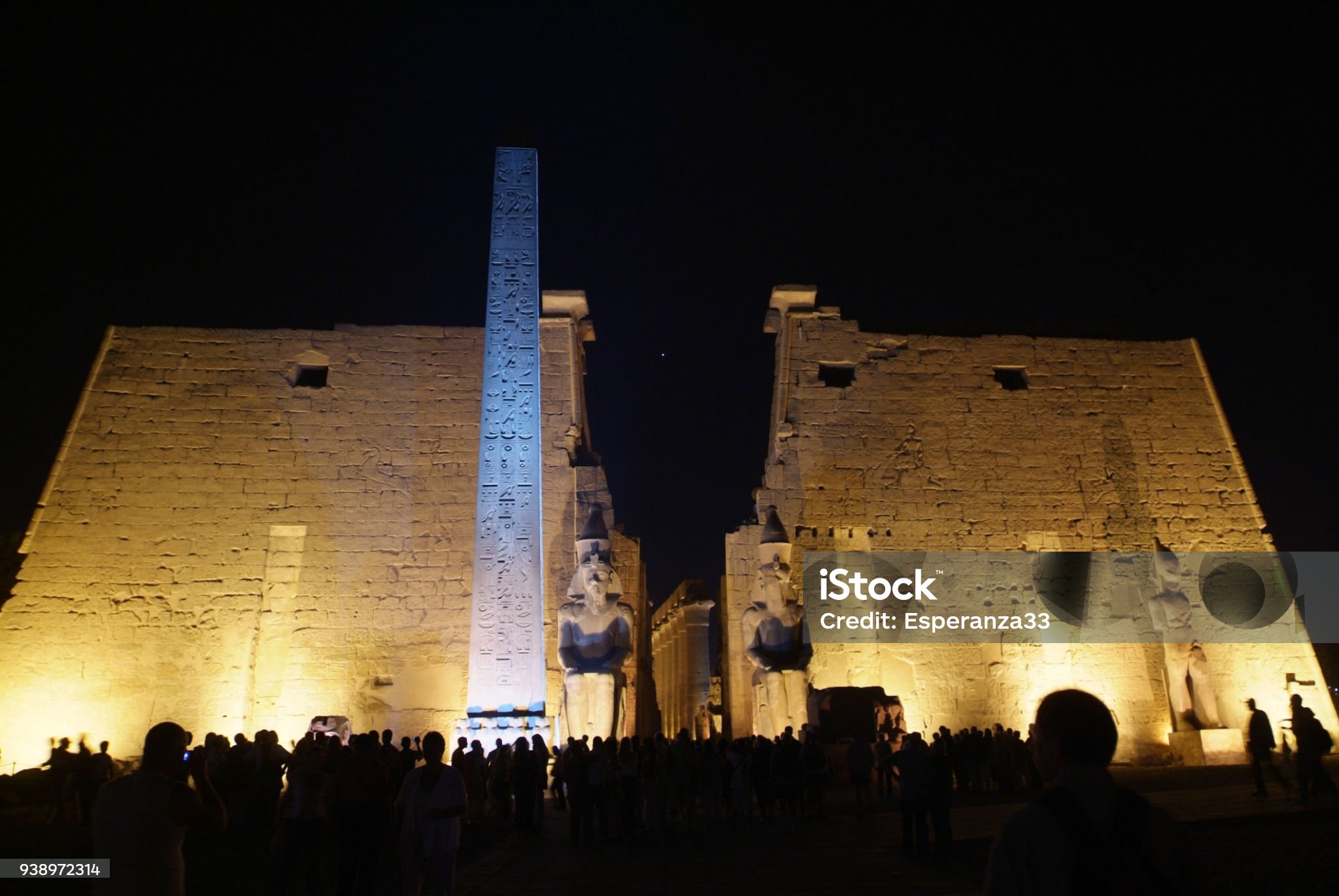 이집트의 고대건축물을 저녘시간에 많은 사람들이 모여서 구경하고 있는 사진입니다.