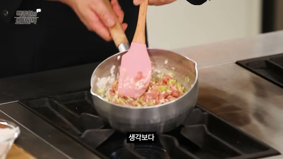 참기름을 두른 냄비에 돼지고기와 채소를 볶는 장면