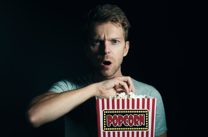 어두운 공간에서 영화를 관람하는 남성